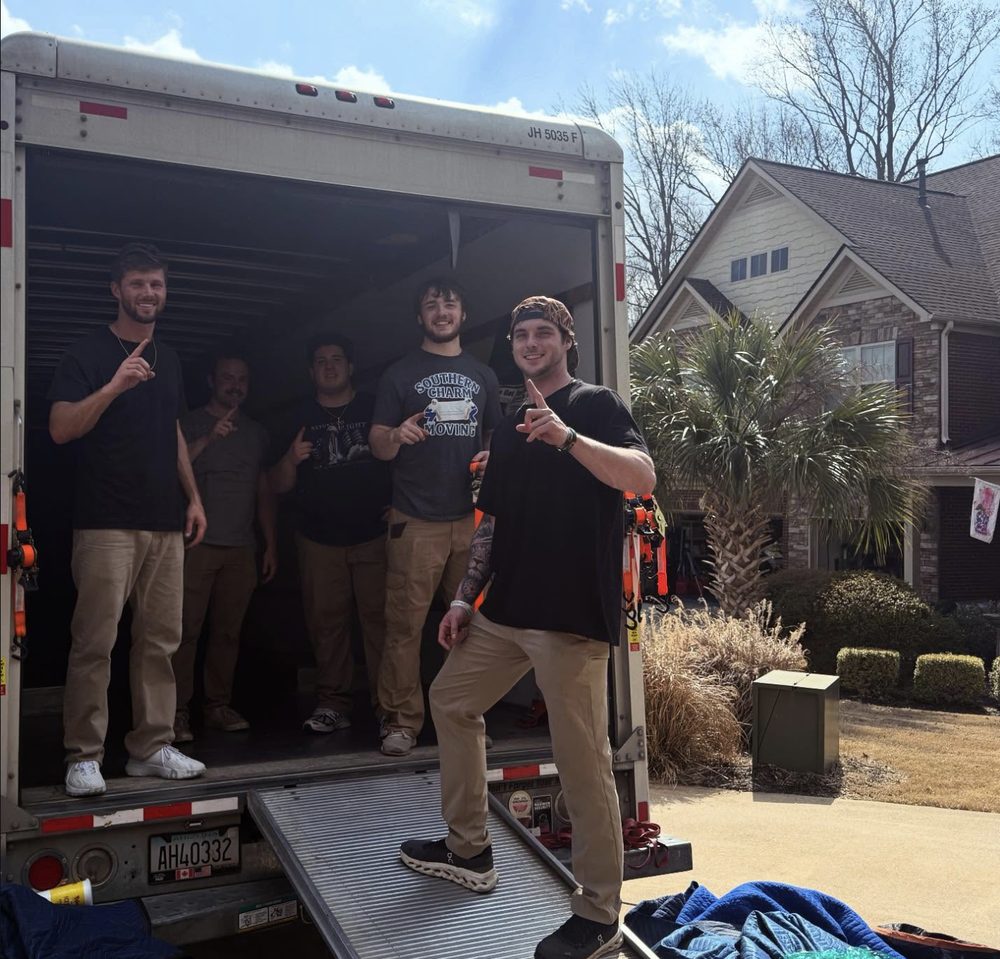 Full Southern Charm crew posing inside the back of a loaded moving truck